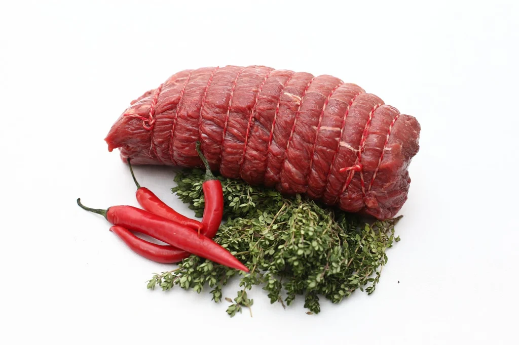 Lean round roast beef on a white cutting board, showing very little marbling compared to chuck roast