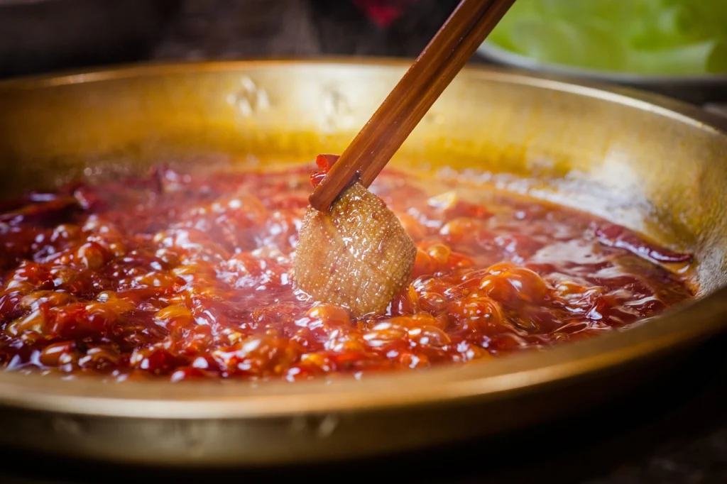 Beef stew gently simmering in a Dutch oven with small bubbles visible