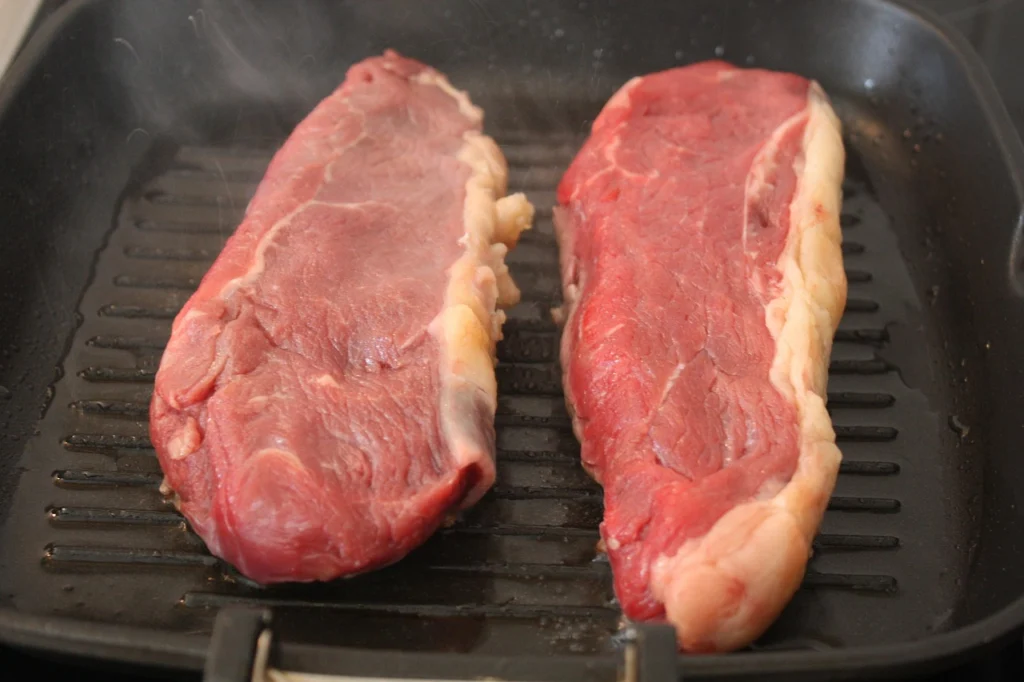 Beef cubes browning in a hot skillet before being added to stew