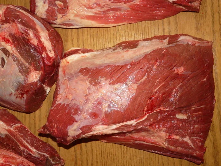Raw chuck roast with visible marbling on a cutting board, showing why it is better for beef stew than round roast