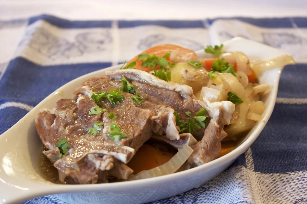 Fork piercing a piece of tender lamb in stew