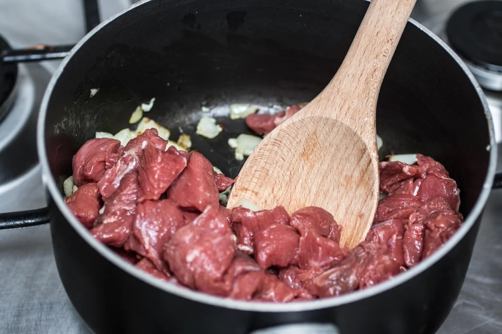 Beef cubes browning in a hot skillet for stew