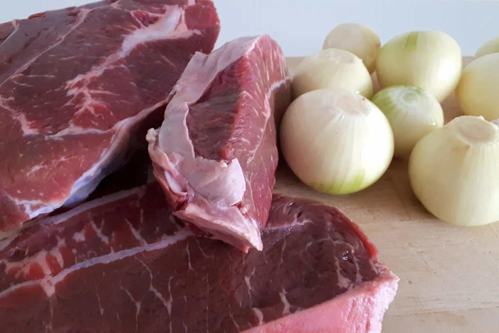 Raw beef stew meat cubes on a cutting board